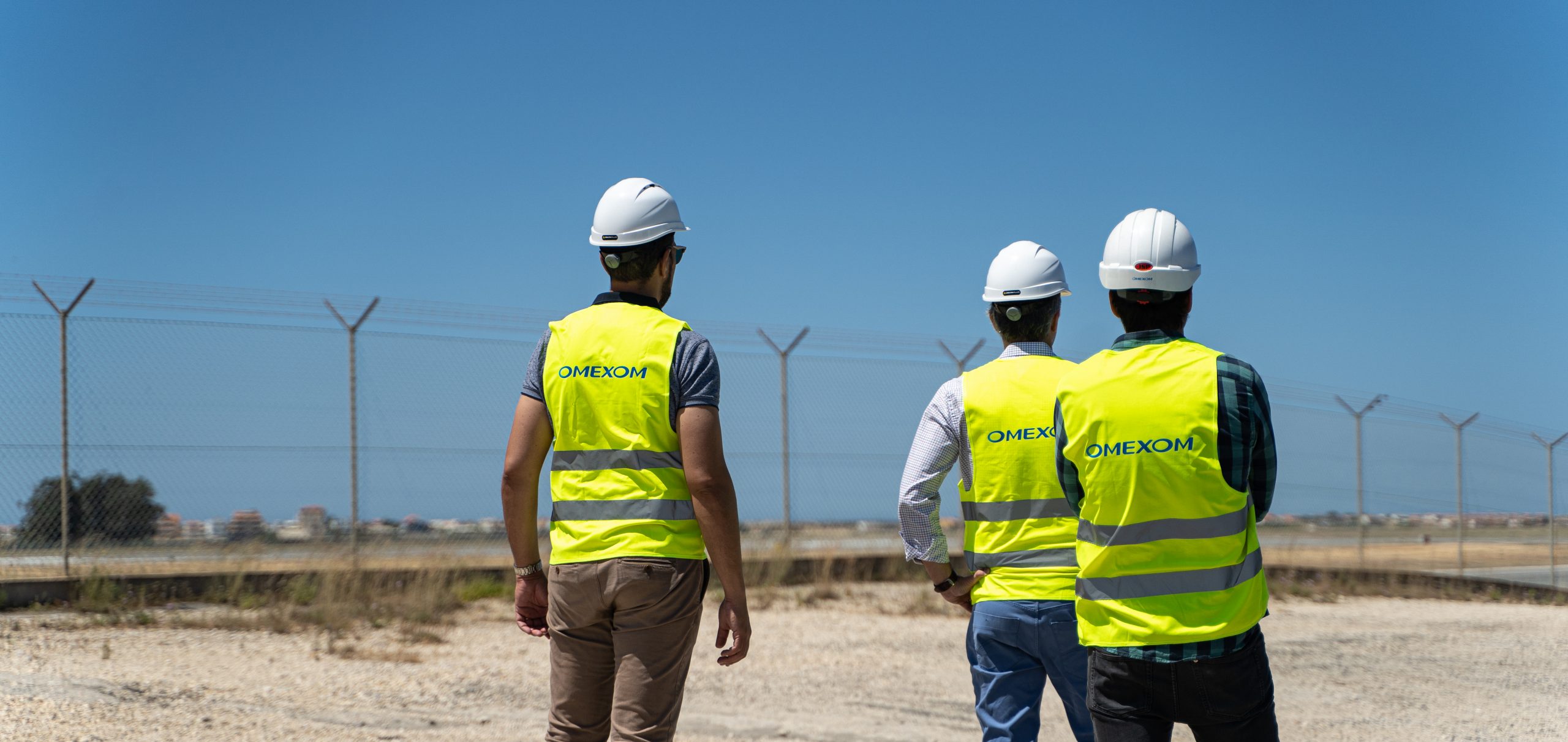 Omexom employees looking out on the solar farm at Faro