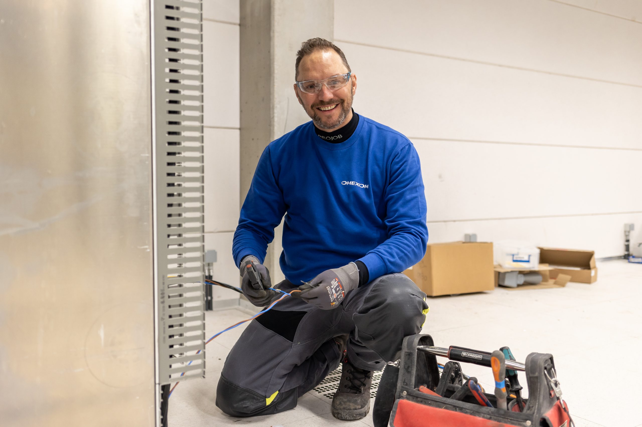 An Omexom employee working on cables in the substation