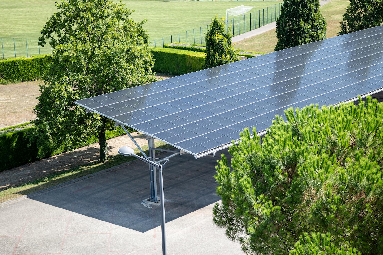 Solar car park structure with elevated photovoltaic panels providing shade and clean energy