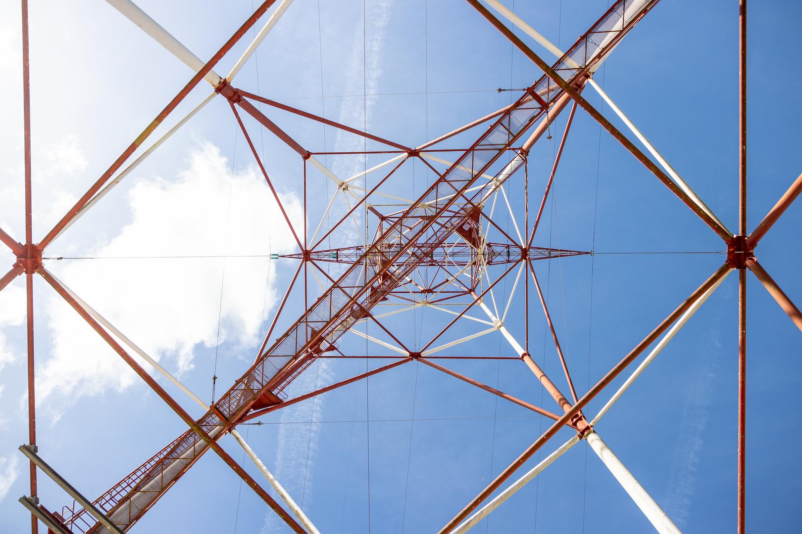 Structural view from inside a steel lattice transmission tower supporting overhead power lines