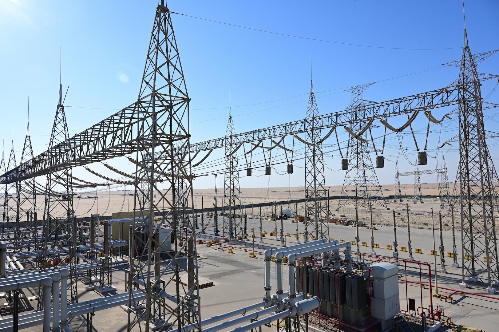High-voltage electrical substation with steel gantries, insulators, and transformer systems
