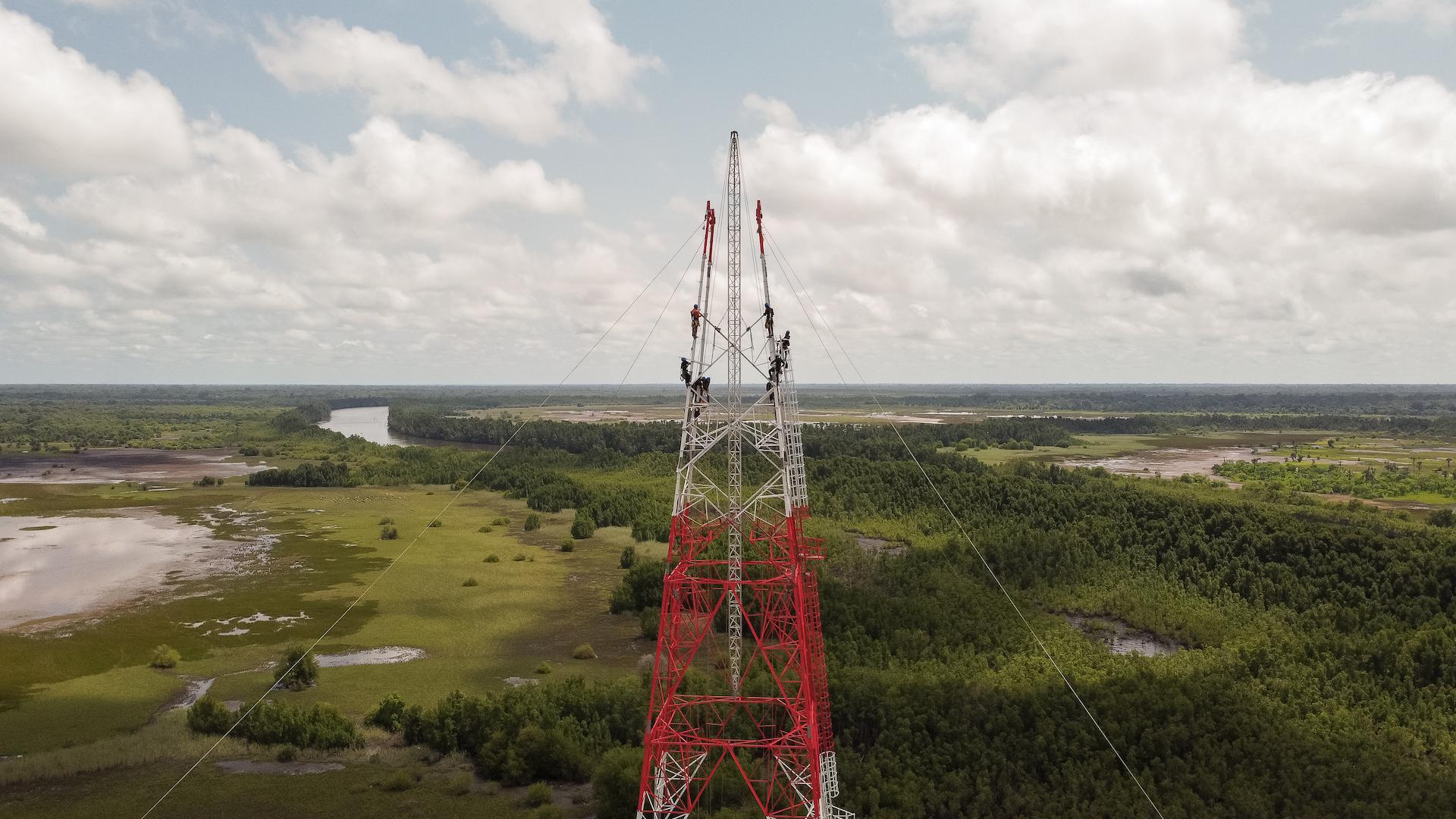 Overhead transmission line construction with conductors being installed on a steel lattice tower