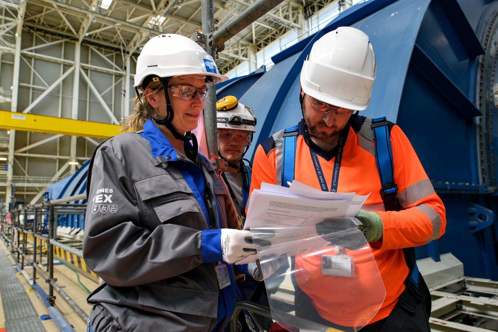 Omexom specialists reviewing technical plans during industrial maintenance and installation operations