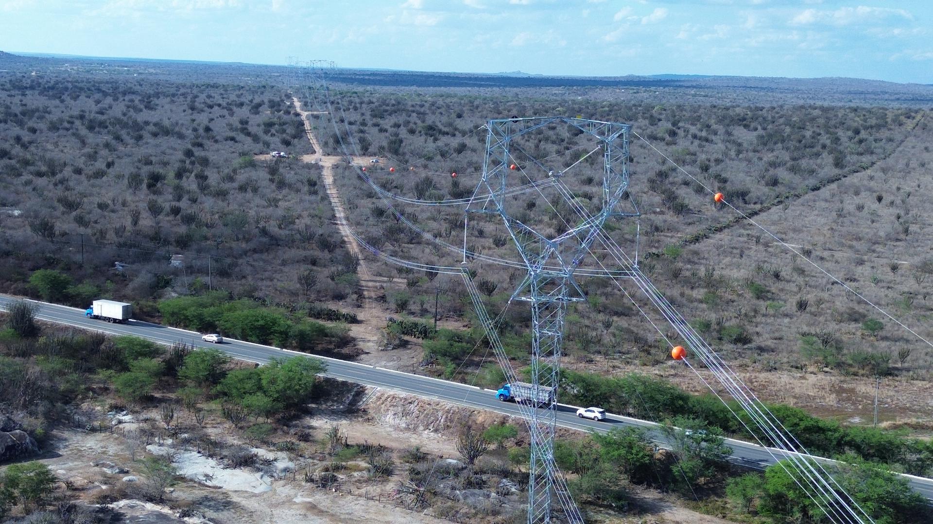 Highvoltage transmission tower crossing a rural road in a semiarid landscape, part of Brazil’s power grid