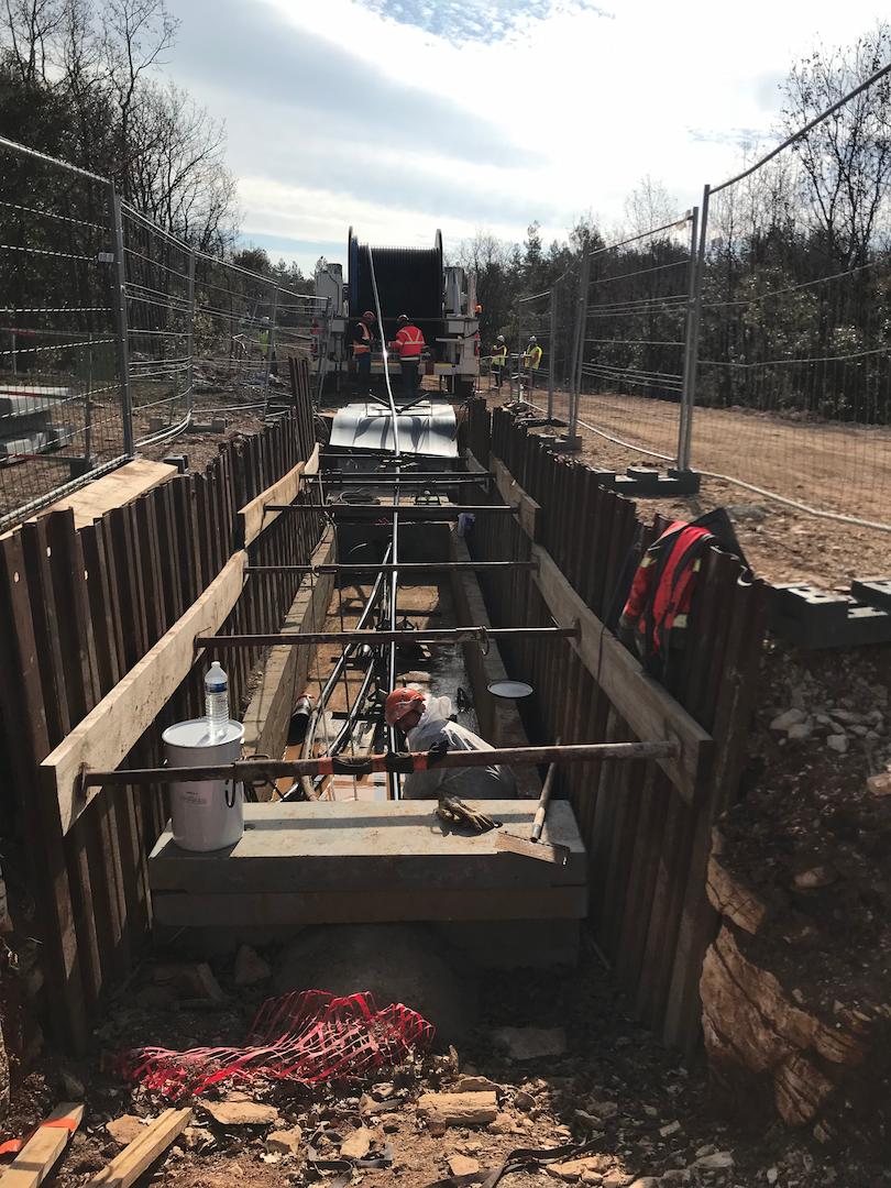 Underground transmission trench with cable reels and installation equipment prepared for highvoltage cable laying