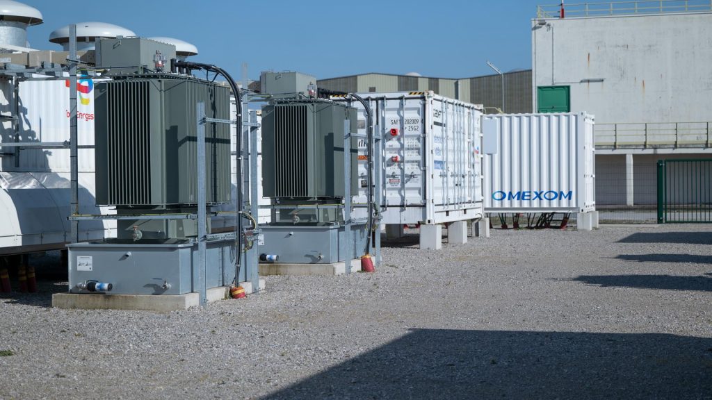 Industrial battery storage units and transformers installed at a modern energy storage site.