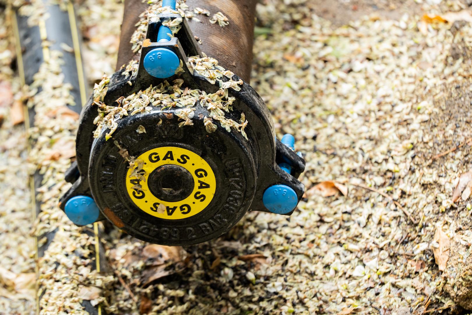 Closeup view of a gas distribution pipe and valve assembly during underground network installation, supporting safe and reliable gas supply infrastructure
