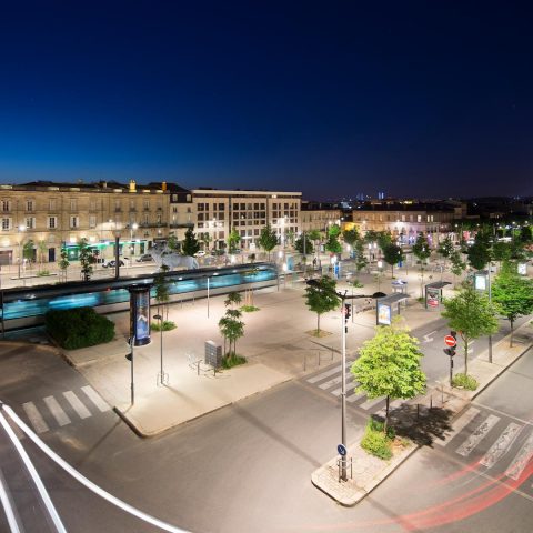 Nighttime cityscape with illuminated streets, public spaces, and traffic flow, showcasing intelligent urban lighting and mobility solutions