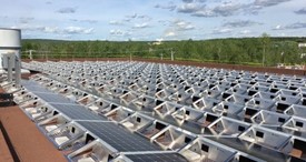 Rooftop solar array installed across a large flat roof with rows of angled photovoltaic units in a microgrid project.
