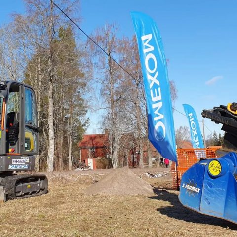 Utility vehicles and machinery positioned in a mountainous landscape for overhead power line installation and electricity distribution works in a rural region