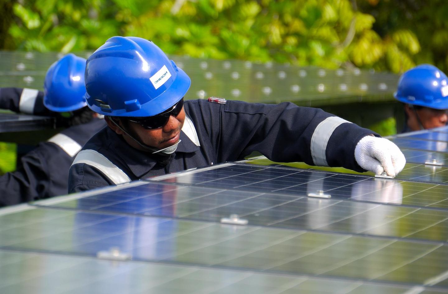 Technicians installing and maintaining solar panels for a renewable energy microgrid, supporting sustainable electricity generation and local energy access