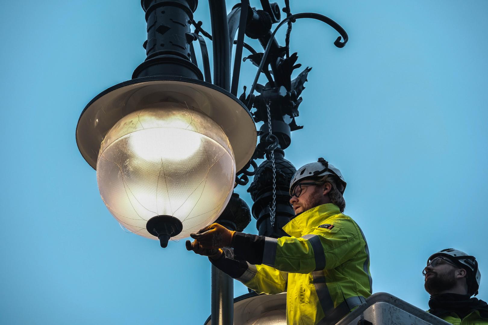 Technician maintaining modern public street lighting infrastructure to ensure reliable and energy-efficient urban illumination