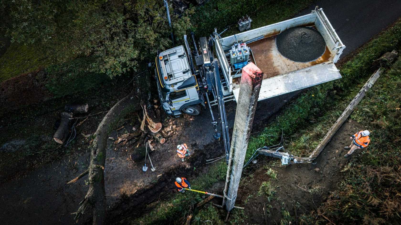 Omexom technician performing overhead line installation from an elevated platform, ensuring reliable electricity distribution across open countryside
