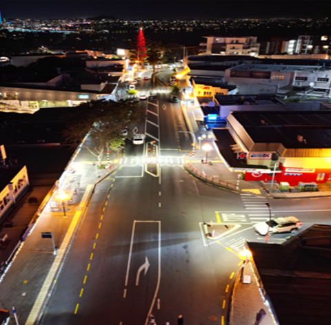 Aerial night view of a city intersection showcasing modern street lighting and urban traffic infrastructure