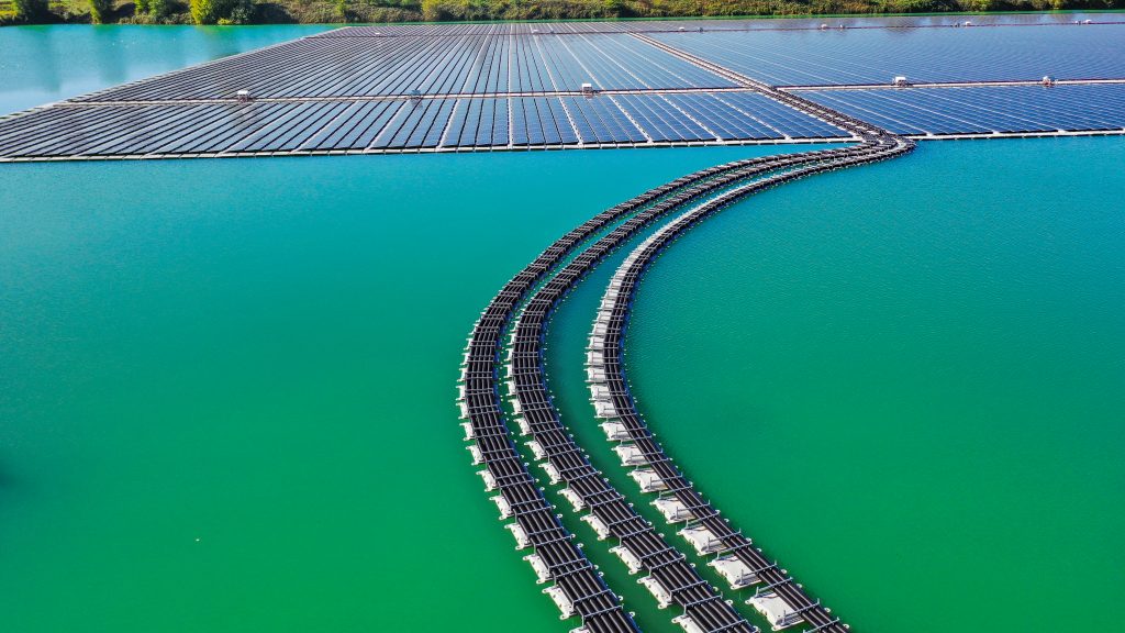 Aerial close-up of floating solar panel rows and electrical cabling at the Saint-Élix-le-Château hybrid solar power plant.